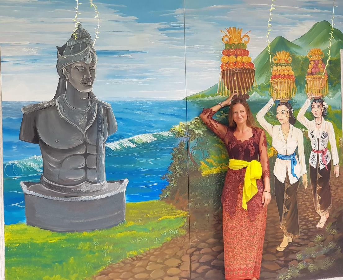 Bali Bobo Hostel Jimbaran Exterior foto A tourist in front of a mural of the statue of King Airlangga in the museum of the Thousand Islands.